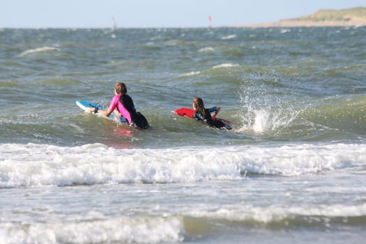 two blonde girls bathing in the sea.