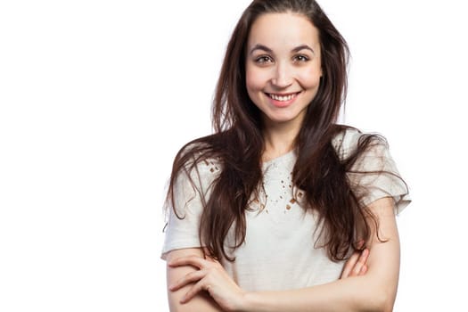 Portrait of a young smiling woman looking relaxed, confident, with her arms crossed, isolated on white