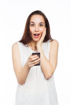 Young woman looking surprised using her phone, looking at the camera, isolated on white