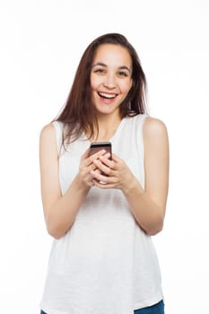 Young woman laughing using her phone, looking at the camera, isolated on white