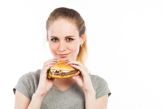 Portrait of a cute young woman holding a burger, isolated on white