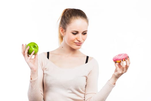 Portrait of a beautiful girl with a green apple and a donut, isolated on white