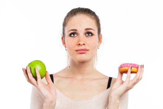 Portrait of a beautiful girl with a green apple and a donut, isolated on white
