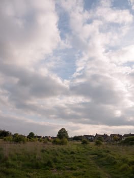 scene of countryside outside with clouds and path through the country to walk landscape peace in spring late afternoon