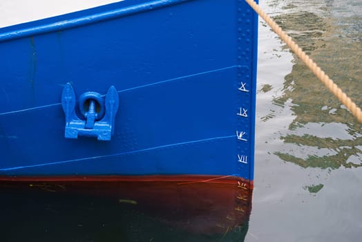 bow of  a blue boat with anchor and draft markings