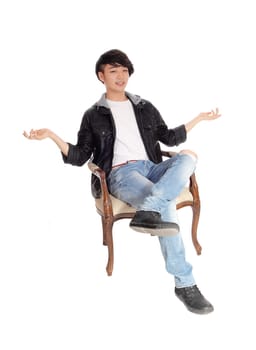 A young Asian man sitting in an old armchair with his hands up and.dos not know what to do, isolated for white background..