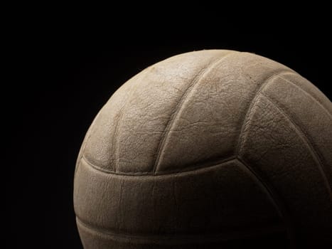 Old used vintage volleyball on a dark background