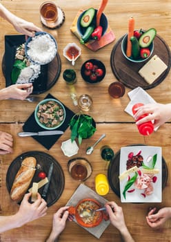 Top view, Group of people sitting at the wooden table having meal