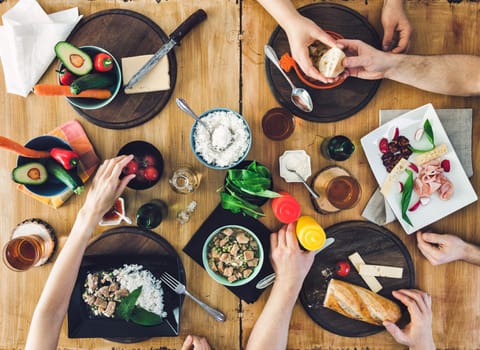 Top view, Group of people sitting at the wooden table having meal