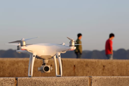 KAGAWA, JAPAN - APRIL 29, 2017: White drone Dji Phantom4Pro stay on concrete brick and ready to fly