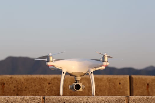 KAGAWA, JAPAN - APRIL 29, 2017: White drone Dji Phantom4Pro stay on concrete brick and ready to fly　