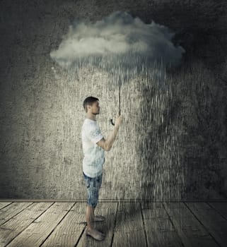 Boy stand in a room, holding a stormy, rainy cloud as umbrella. Business pessimism concept