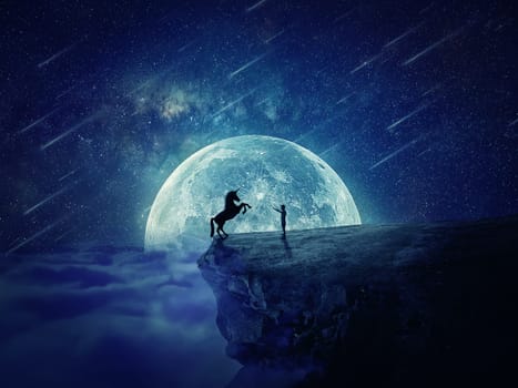 Night scene with a boy standing at the edge of a cliff chasm trying to tame a wild unicorn. Begining of a new friendship, fearless symbol