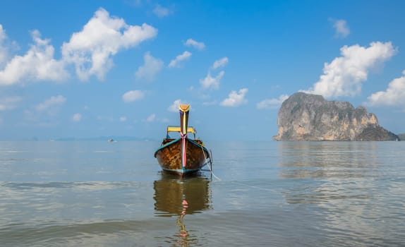 Seascape with limestone mountain and wooden long-tail boat at Pak Meng Beach in Trang province, Thailand