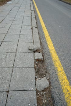 Road and sidewalk with broken curb in road construction