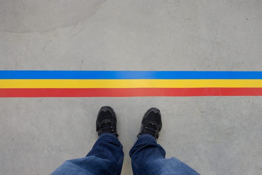 Legs with jeans and shoes in front of a line with text space