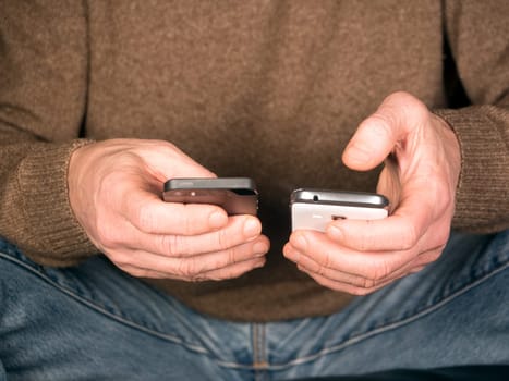 Hands hold two smartphones