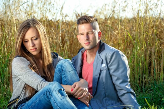 portrait of happy smiling young couple in love embracing outdoor at sunny day