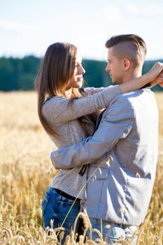 portrait of happy smiling young couple in love embracing outdoor at sunny day