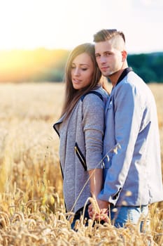 portrait of happy smiling young couple in love embracing outdoor at sunny day