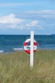 orange with white life buoy along a danish beach