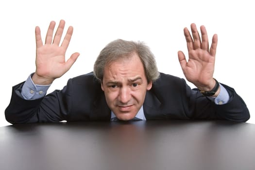 scared mature businessman on a desk, isolated on white