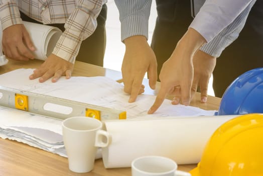 Business teamwork working on blueprint, engineering tools, soft light effect, selective focus