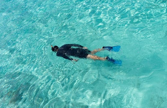 Young woman snorkeling in tropical water on vacation