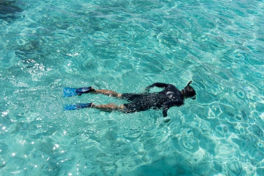 Young woman snorkeling in tropical water on vacation