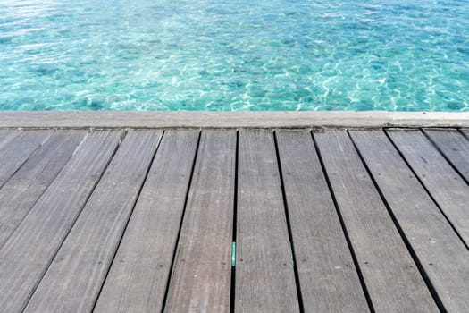 Wooden floor with clear sea water, maldives
