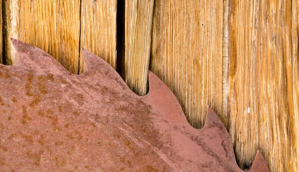 A metal circular saw blade mounted on a wood shed wall