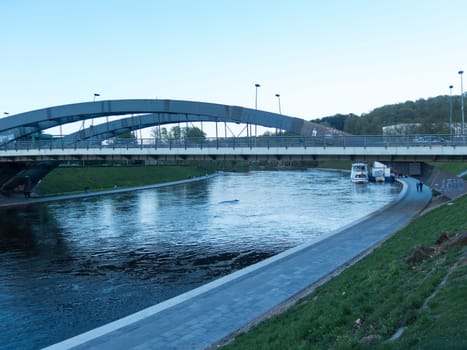 the river Neris is floating in the city of Vilnius under the bridge