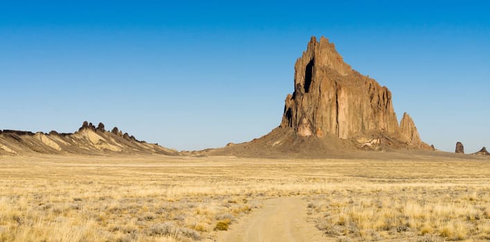 Blue skies appear in a panoramic view of Shiprock
