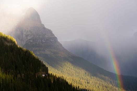 A storm passes over the center of Glacier National Park creating a rainbow
