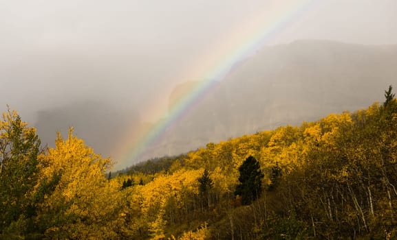 A storm passes over the east entrance of Glacier National Park creating a rainbow