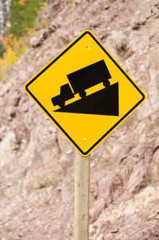 Sign with a truck going down a wedge shape on the roadside