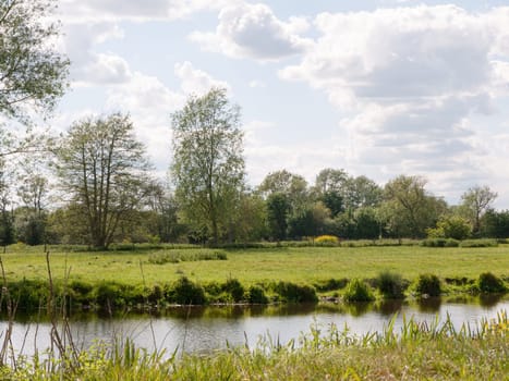 a river running through a country scene outside in the uk essex of england on a summer's day and afternoon very nice