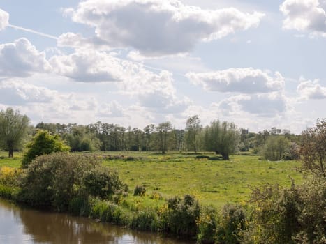 a lush afternoon summer scene outside in the country with a river at the bottom side and lots of open space and green land in england essex of the uk peace