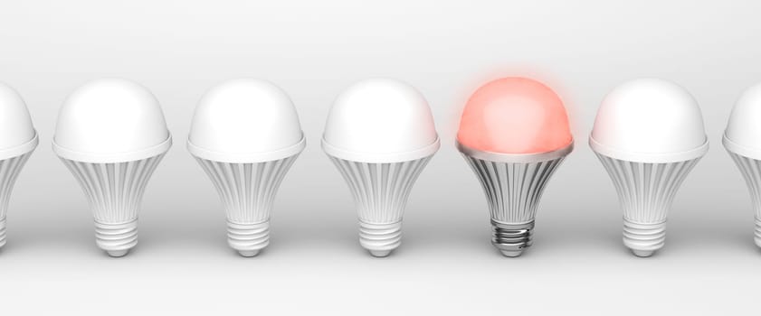 One unique glowing light bulb among others on white background