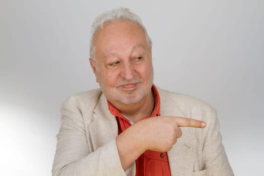 Senior points his finger on a light background