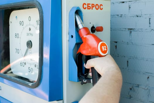 man at a gas station fills the fuel in the vehicle tank