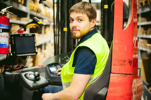 young man in working clothes, driver Reachtruck busy working on the logistics warehouse store