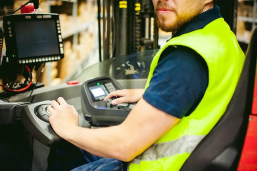 young man in working clothes, driver Reachtruck busy working on the logistics warehouse store