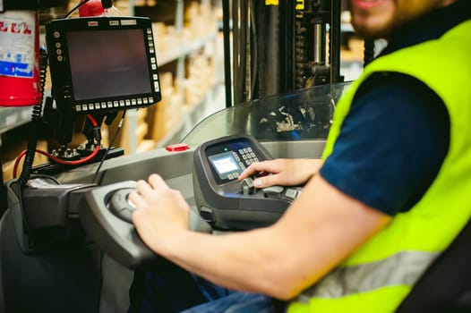 young man in working clothes, driver Reachtruck busy working on the logistics warehouse store