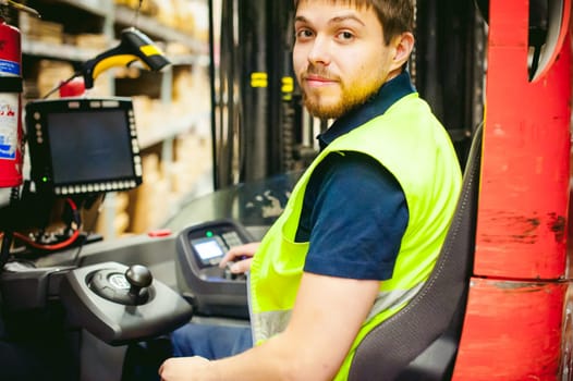 young man in working clothes, driver Reachtruck busy working on the logistics warehouse store