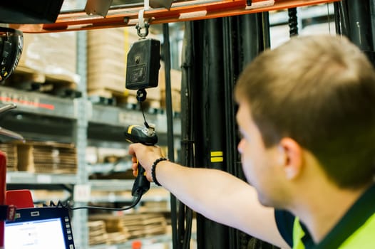 young man in working clothes, driver Reachtruck busy working on the logistics warehouse store