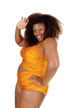 An African American young woman standing in profile in a orange bikini,.and waiving with her hand, isolated for white background..