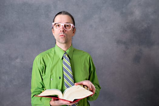 angry lawyer in green shirt and necktie with statute book and pink glasses