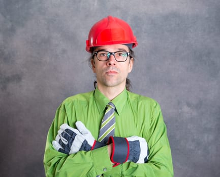 young architect in green shirt with red helmet and crossed arms