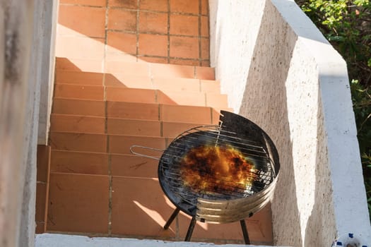Used round simple BBQ grill filled with charcoal..